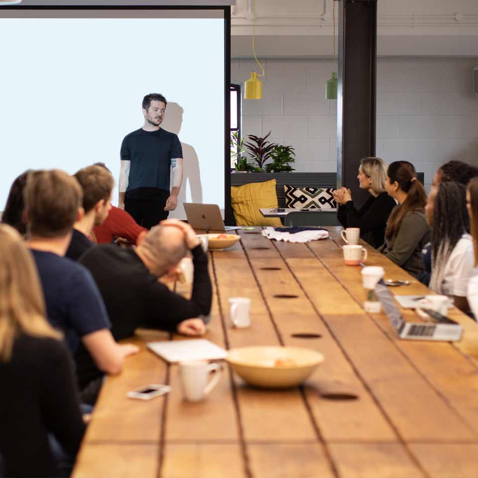 Habito's CEO, Dan speaking at the all hands meeting to a room of people eagerly watching.